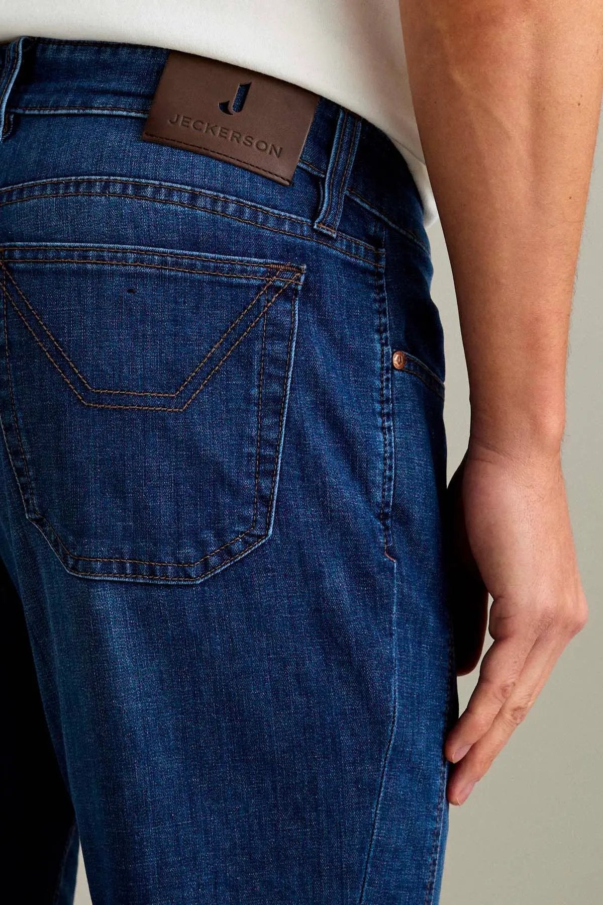 Jeans uomo in denim blu con etichetta in pelle sul retro e cuciture a contrasto
