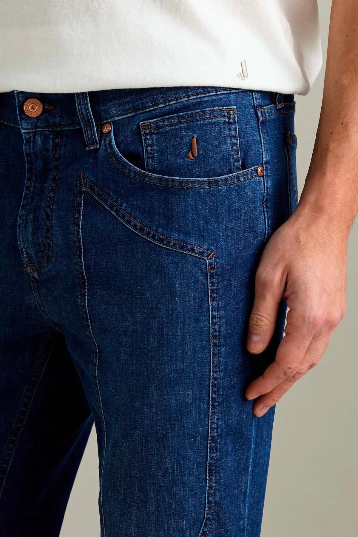 Dettaglio jeans uomo in denim blu con impunture a contrasto e tasche frontali