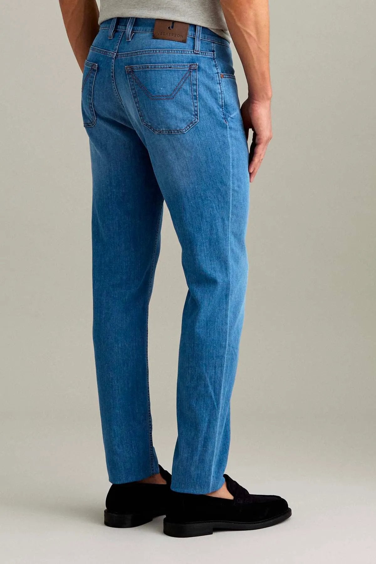 Jeans uomo denim chiaro a cinque tasche vestibilità regular, dettaglio etichetta posteriore.