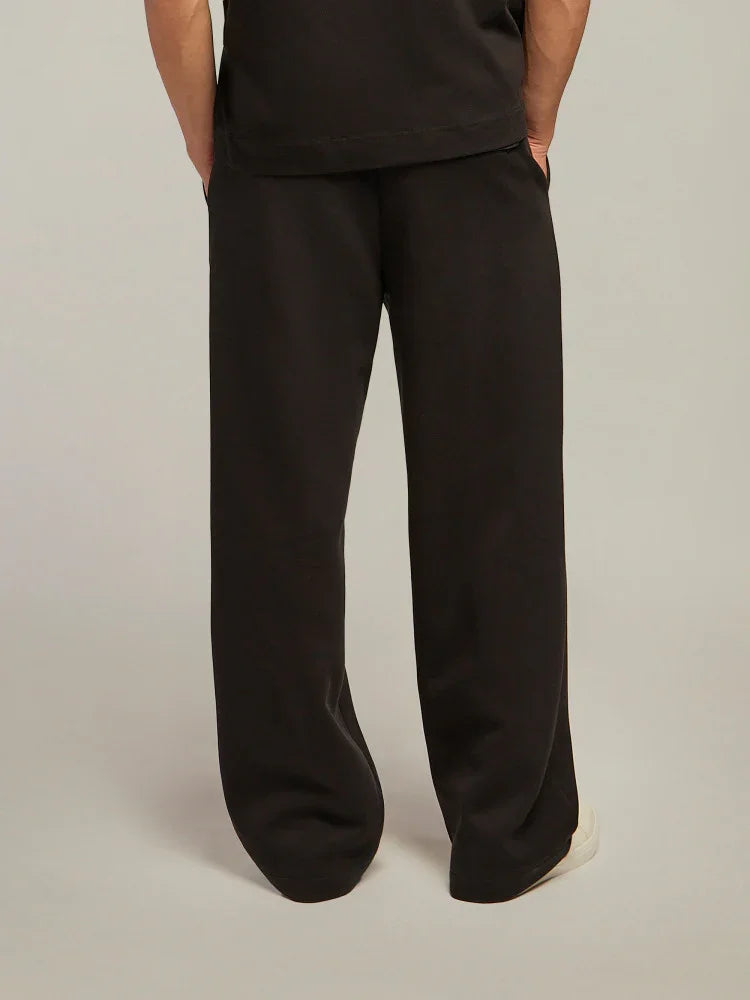 Pantaloni uomo neri a gamba larga, stile casual, indossati con sneakers bianche
