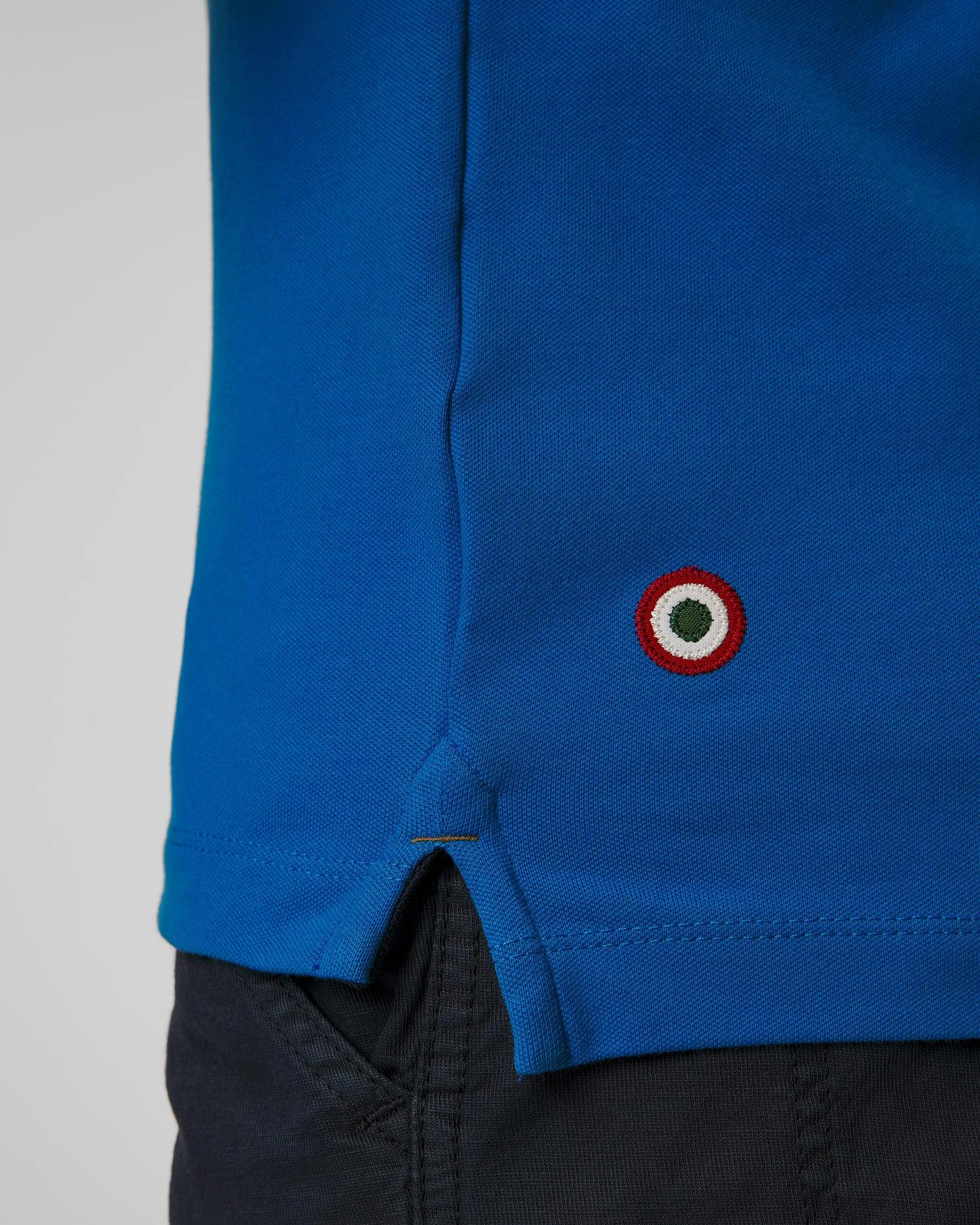 Dettaglio polo blu uomo con piccolo logo circolare ricamato e spacco laterale