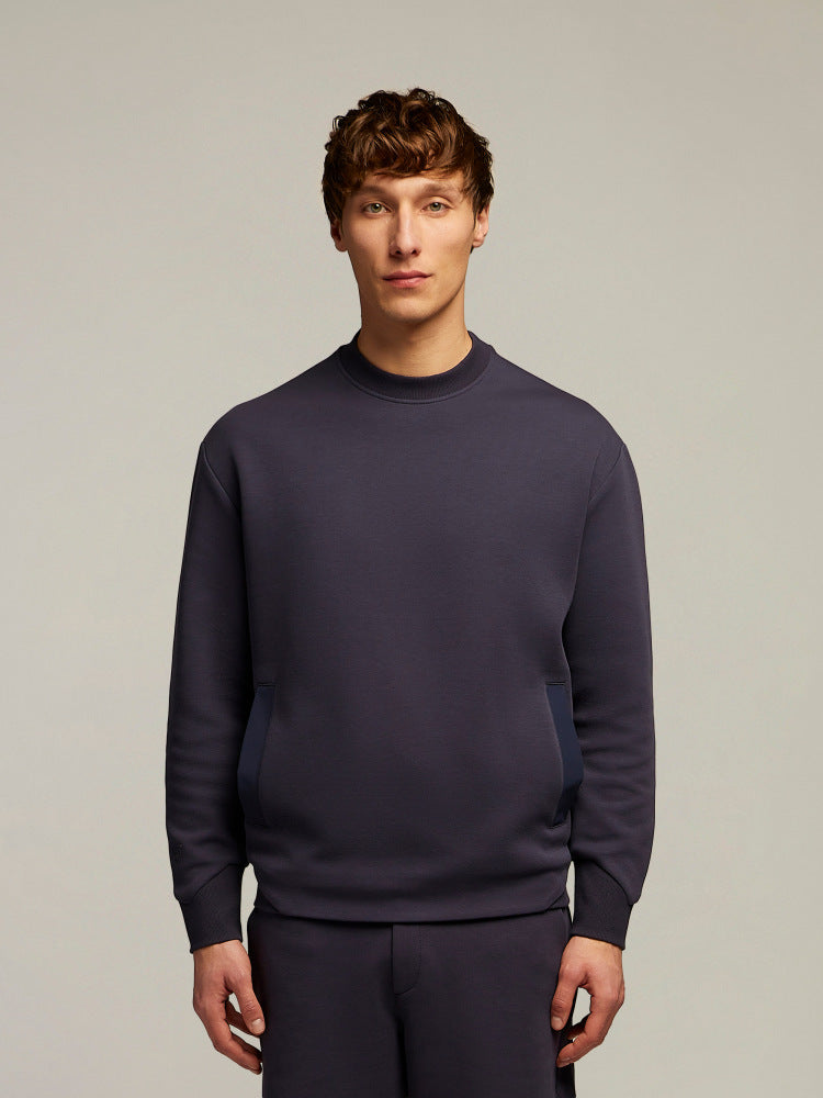 Modello uomo indossa felpa girocollo blu scuro, abbigliamento uomo elegante e casual.