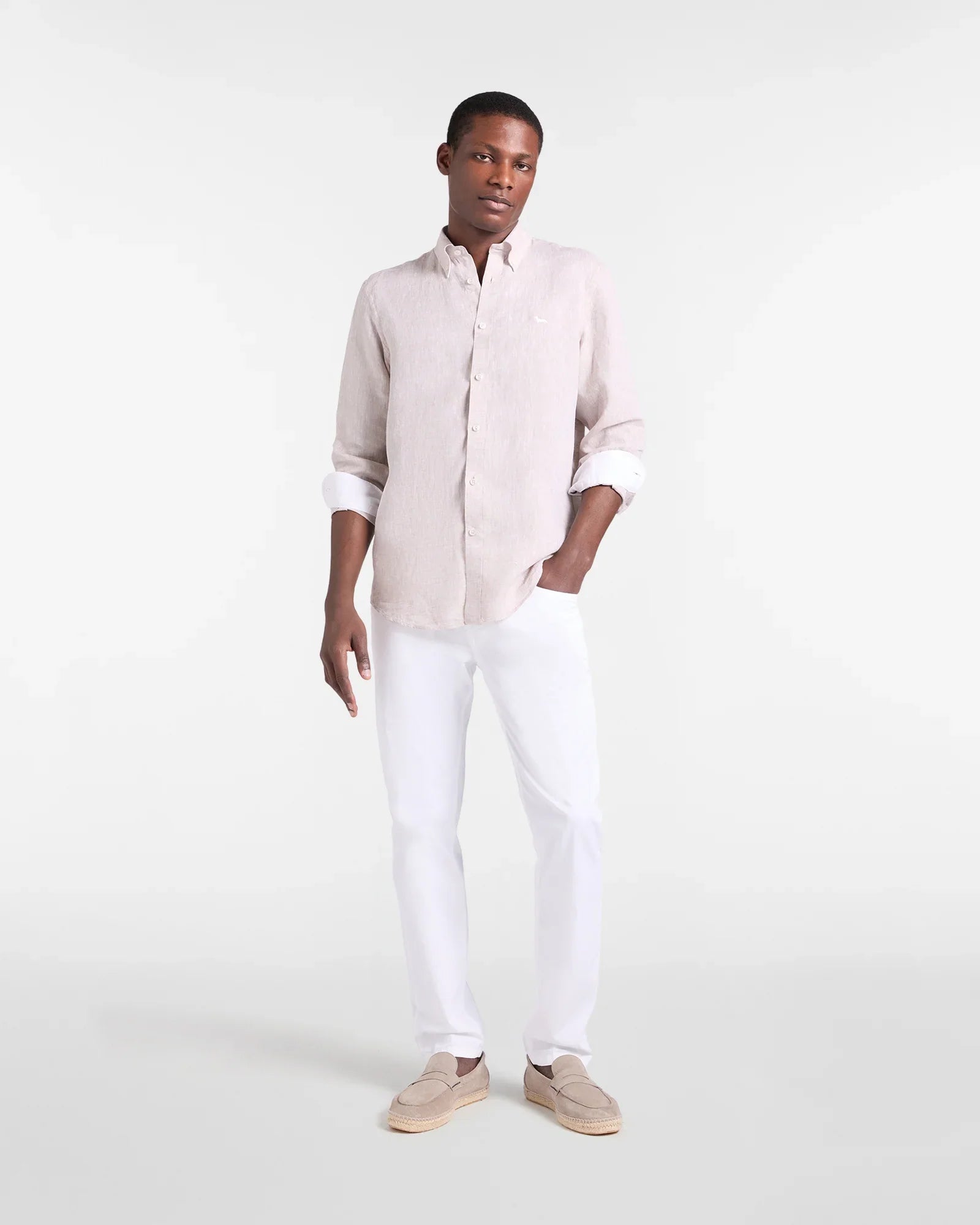 Modello uomo con camicia lino beige, pantaloni bianchi e mocassini beige, moda elegante
