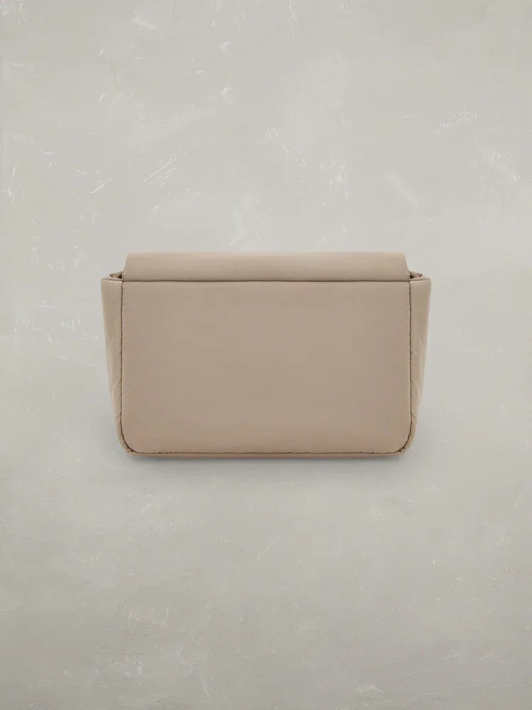 Borsa a tracolla beige da donna su sfondo chiaro, stile minimal e moderno.