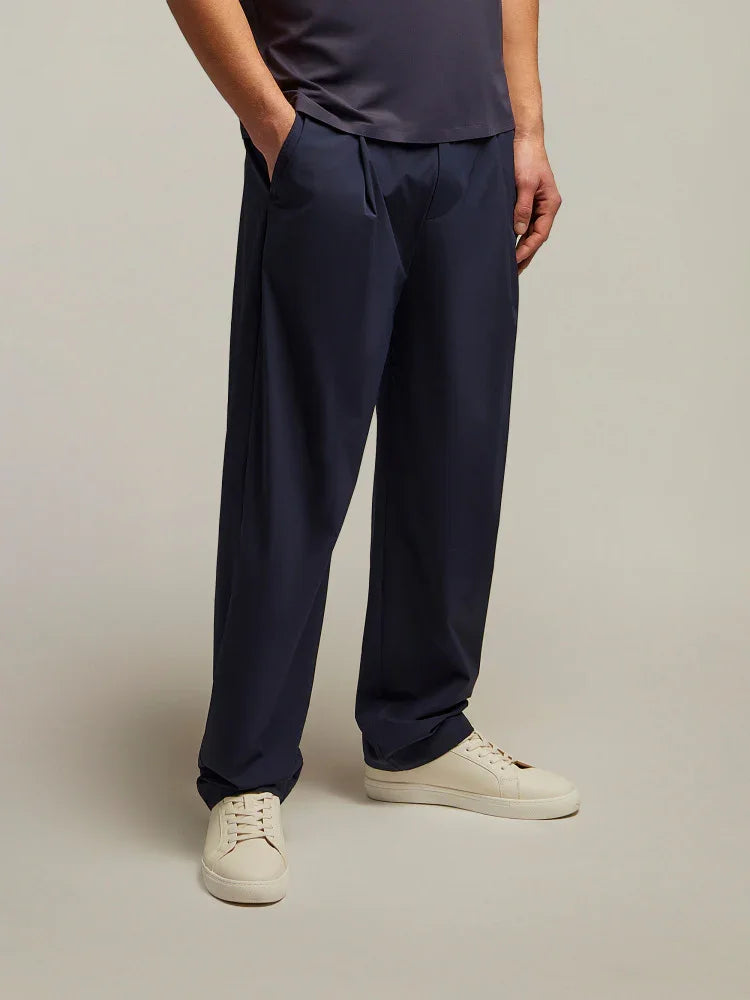 Pantaloni uomo blu eleganti a gamba larga, abbinati a sneakers bianche, stile moderno