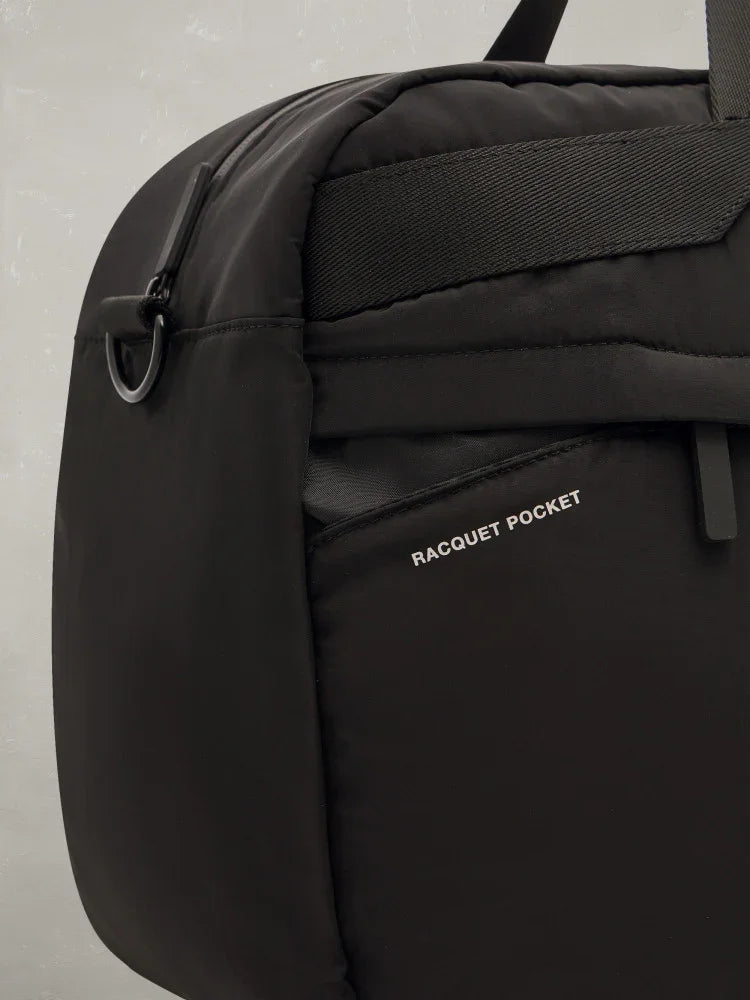 Borsa sportiva nera con tasca porta racchetta, dettaglio laterale ed etichetta Racquet Pocket