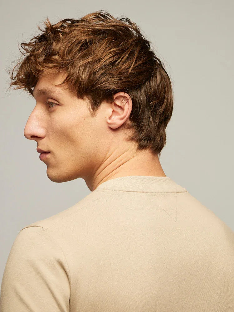 Uomo di profilo con capelli castani e maglia beige, moda uomo casual elegante.
