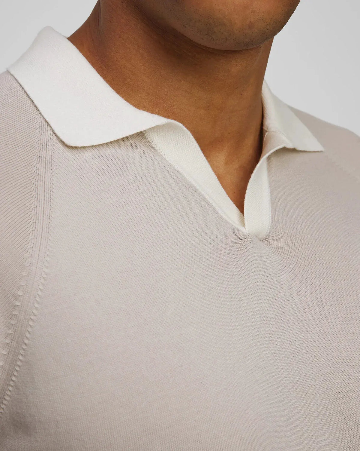 Dettaglio polo uomo beige chiaro con colletto bianco in maglia, abbigliamento elegante
