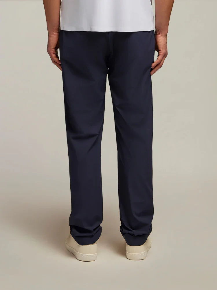 Pantaloni uomo blu scuro, vestibilità classica, indossati con sneakers bianche