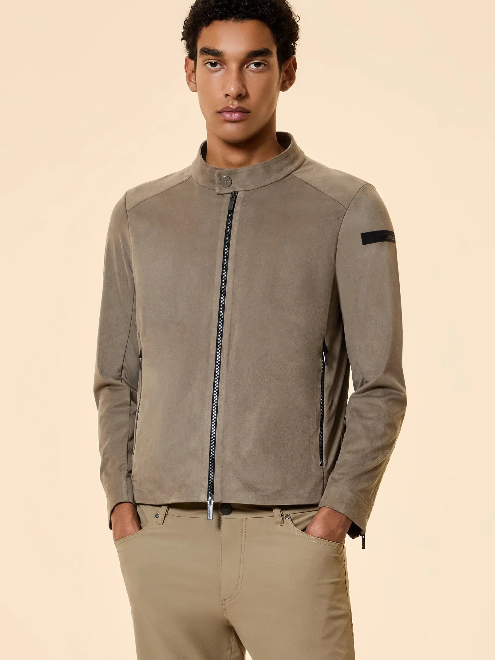 Giacca uomo beige con zip, stile casual elegante, indossata da modello su sfondo neutro.