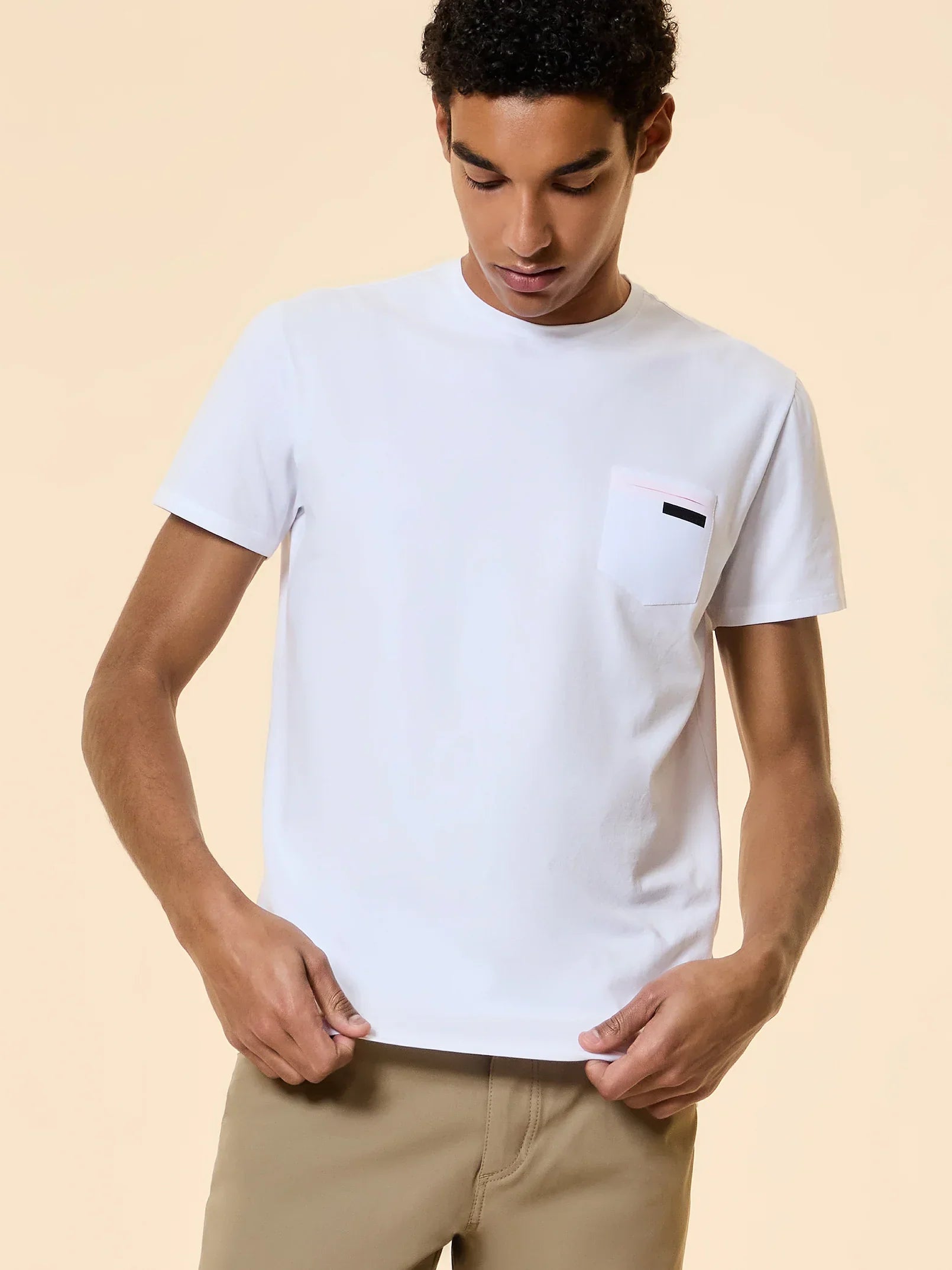 Maglietta bianca uomo con taschino, abbigliamento casual su sfondo neutro.