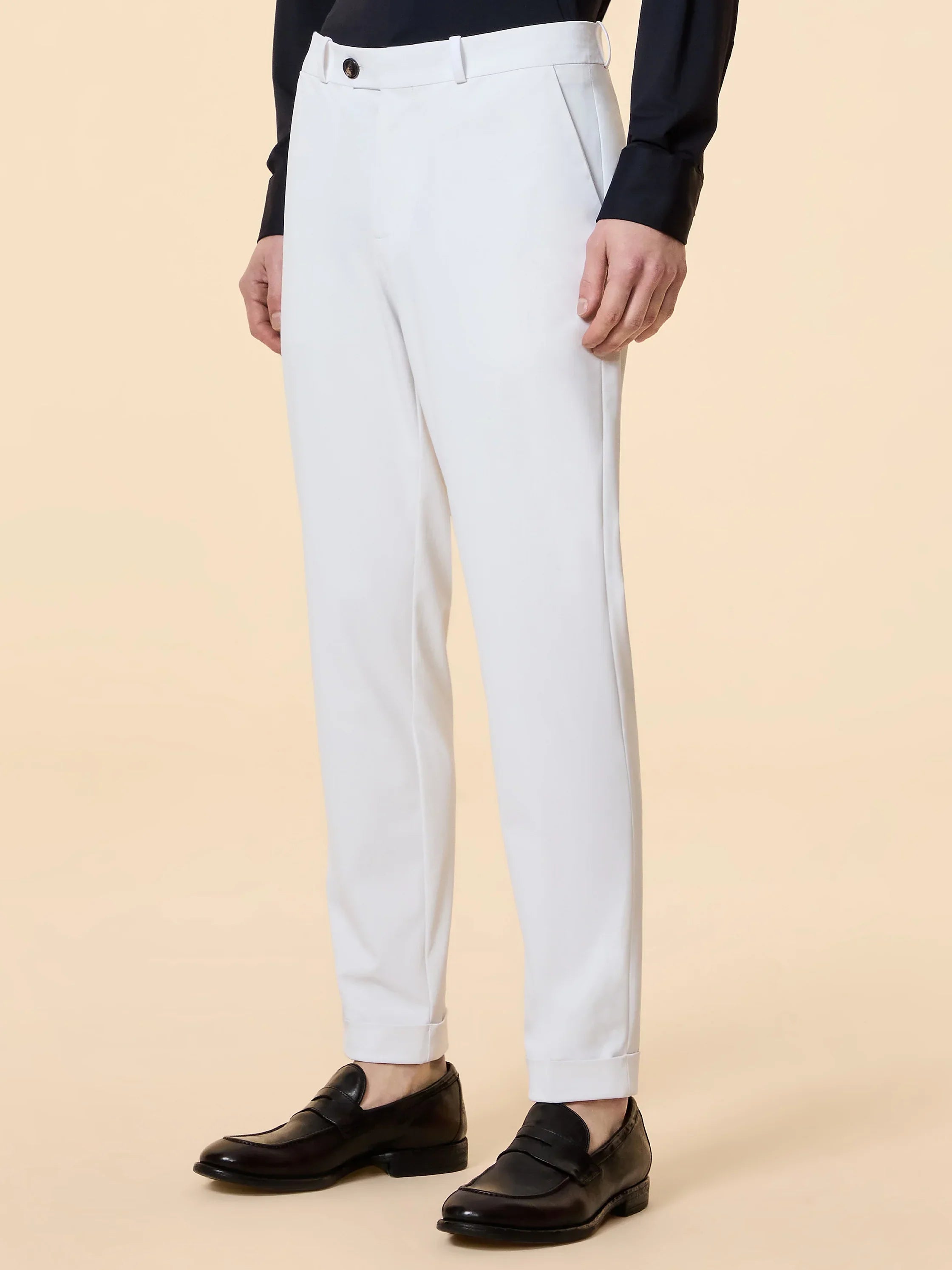 Pantaloni eleganti uomo bianchi con piega, indossati con mocassini neri e camicia scura