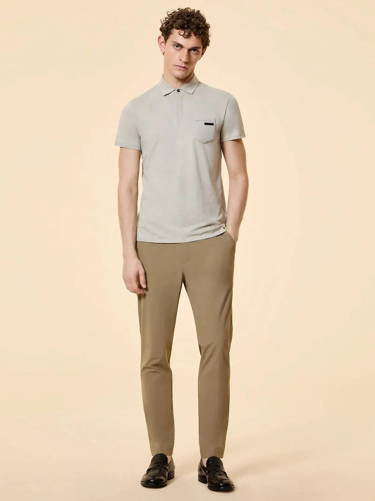 Modello indossa polo beige a maniche corte e pantaloni slim fit color sabbia uomo eleganti