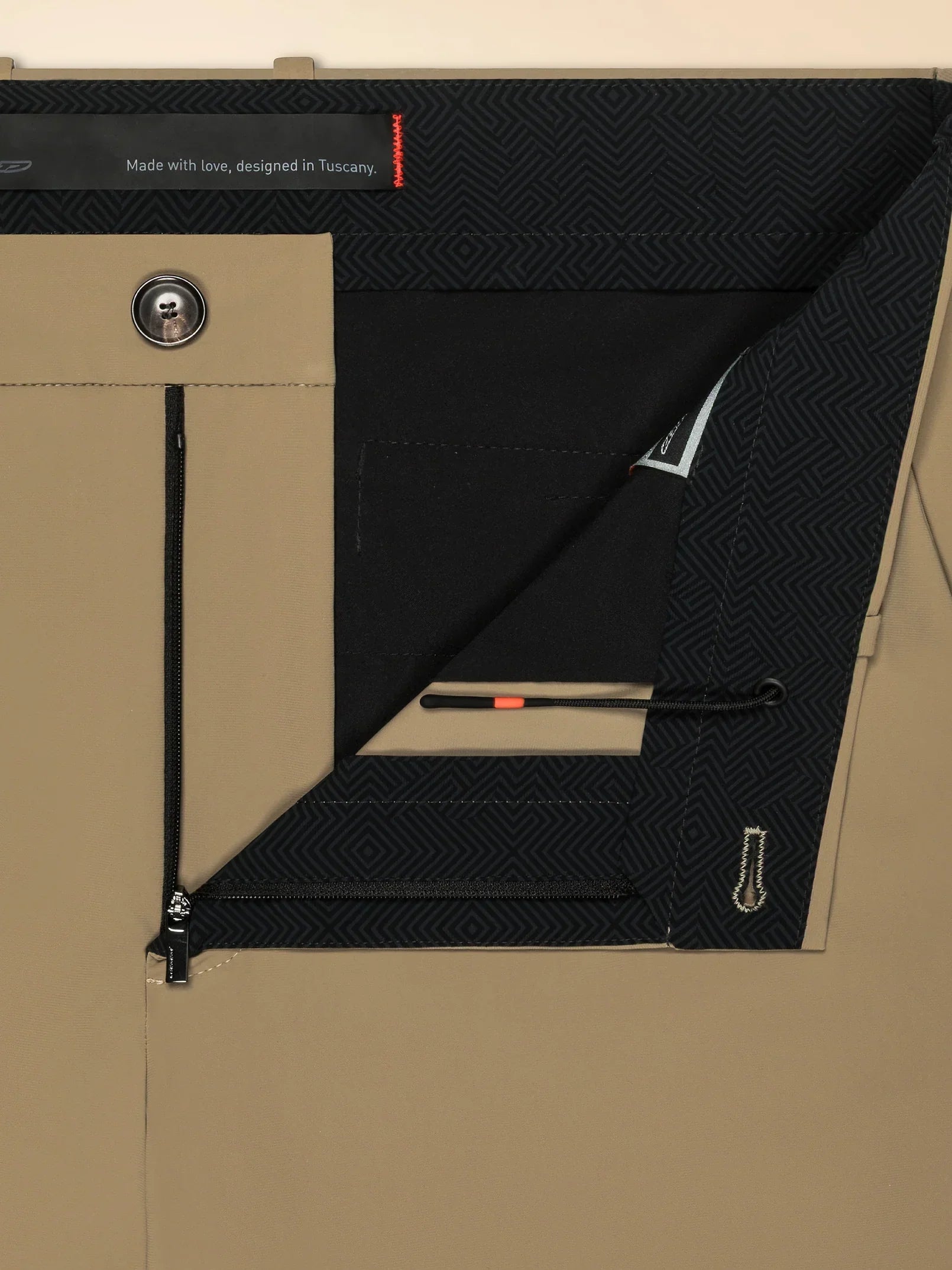 Dettaglio interno di pantaloni beige uomo con zip, bottone e fodera fantasia geometrica