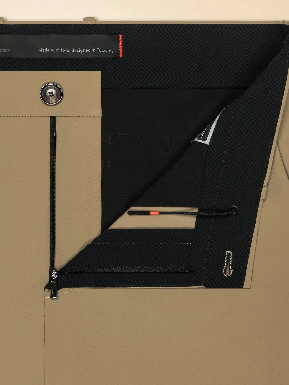 Dettaglio interno di pantaloni beige uomo con zip, bottone e fodera fantasia geometrica