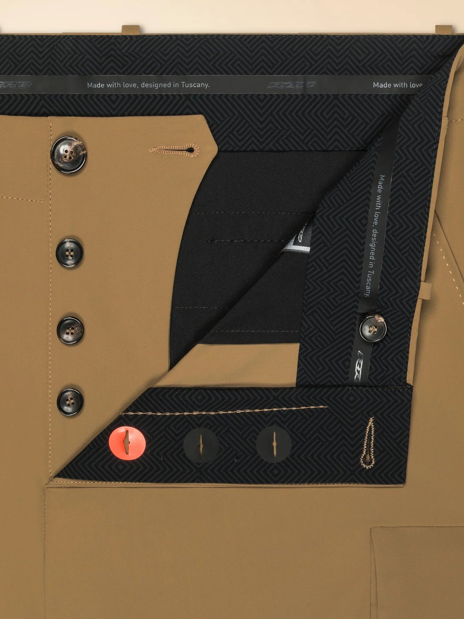 Dettaglio interno pantaloni uomo beige con bottoni e fodera fantasia geometrica nera