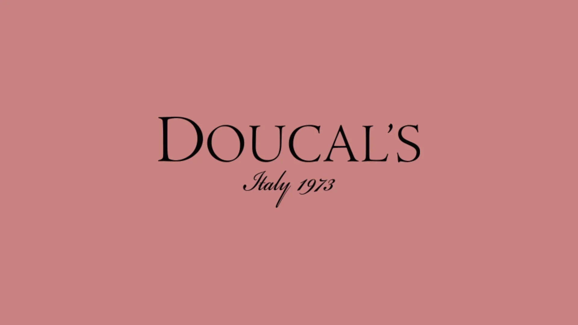 Logo Doucal's Italy 1973 su sfondo rosa, moda italiana uomo donna, calzature accessori