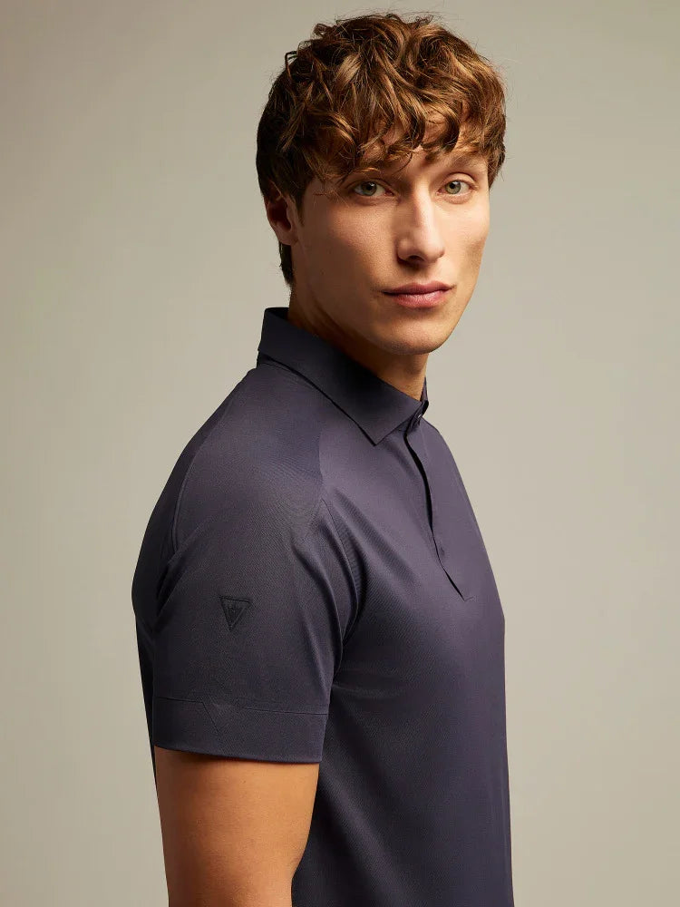 Modello uomo indossa polo blu scuro a manica corta, stile elegante, sfondo neutro