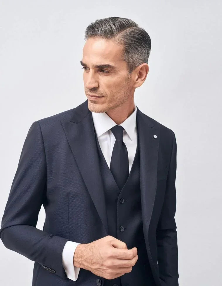Uomo elegante con abito blu scuro, camicia bianca e cravatta nera, stile formale