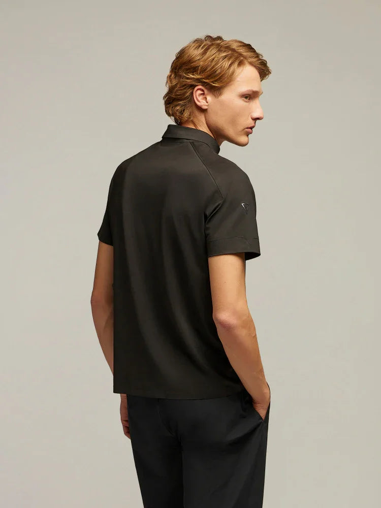 Uomo con polo nera a maniche corte e pantaloni scuri, stile moda maschile elegante.