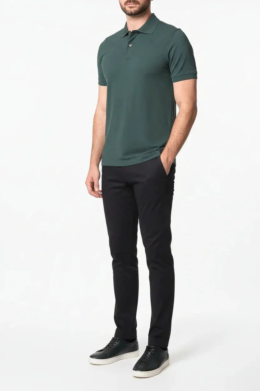 Modello indossa polo verde uomo a maniche corte e pantaloni neri eleganti con sneakers nere