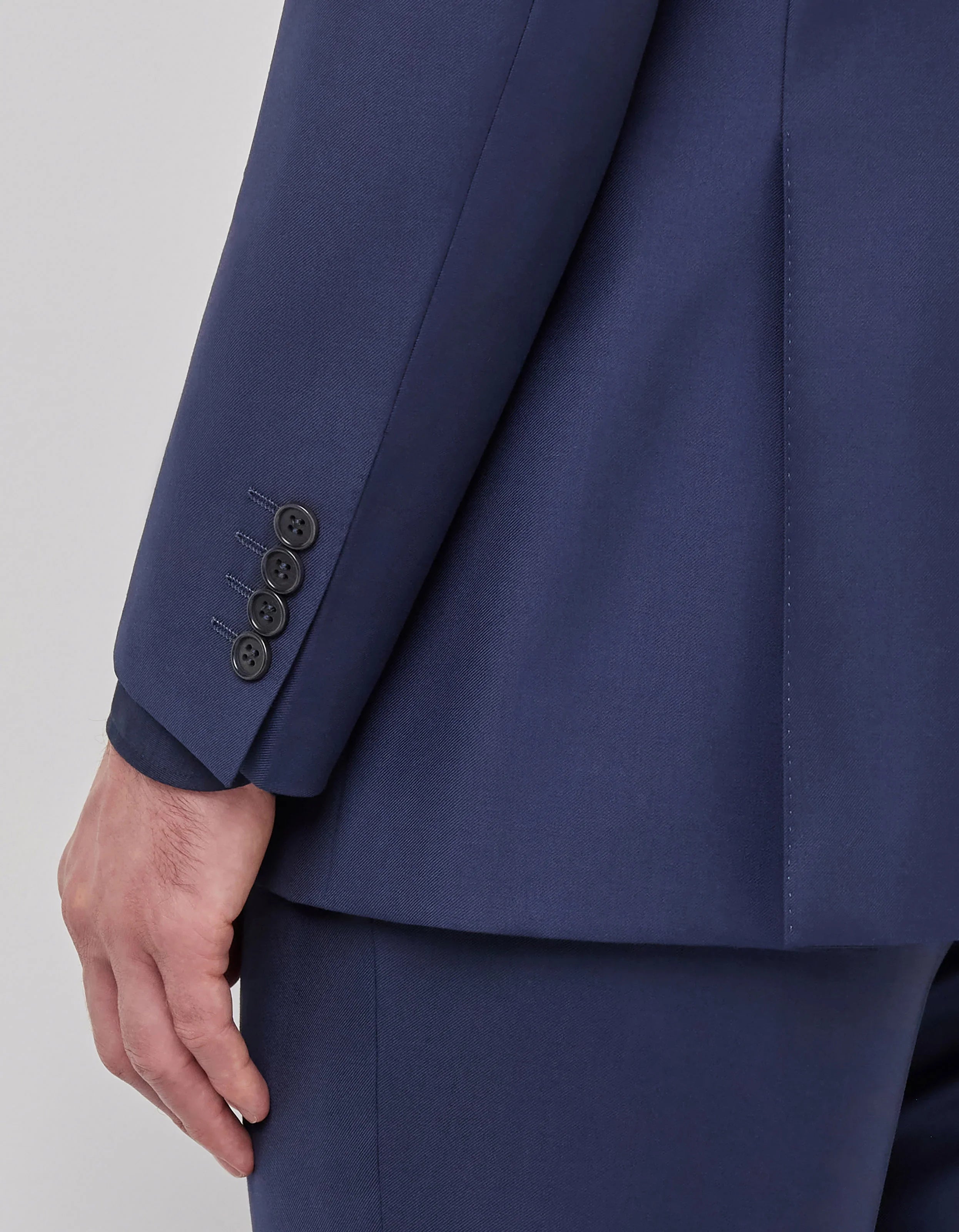 Dettaglio manica giacca uomo elegante blu, bottoni sartoriali, abbigliamento classico