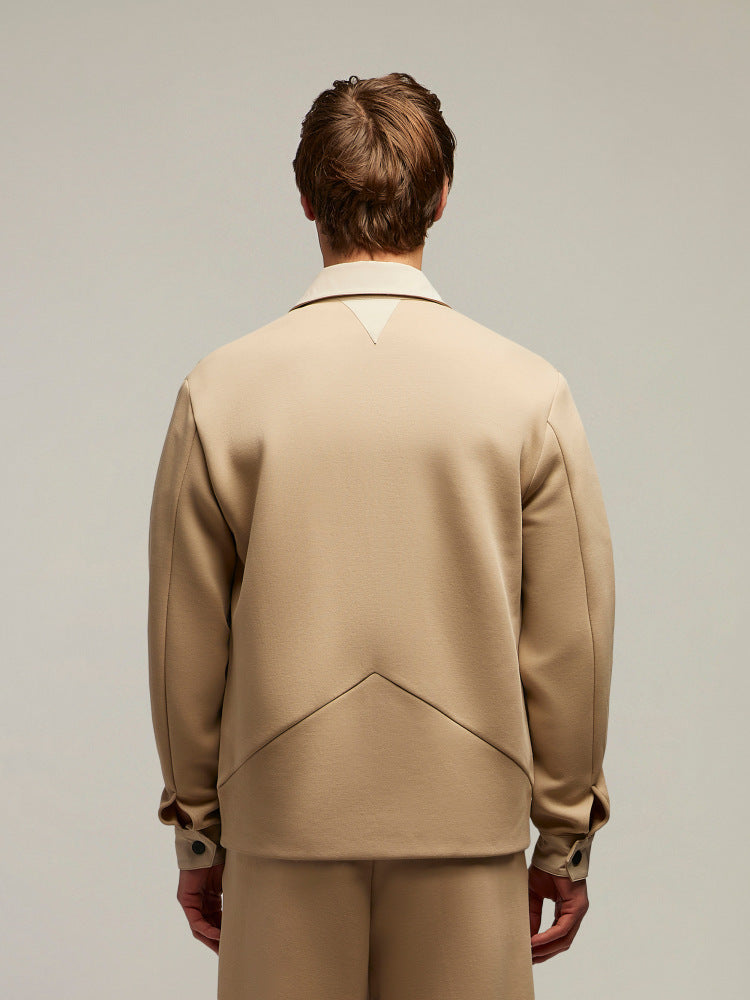 Giacca beige uomo vista posteriore, abbigliamento elegante minimalista, sfondo neutro.