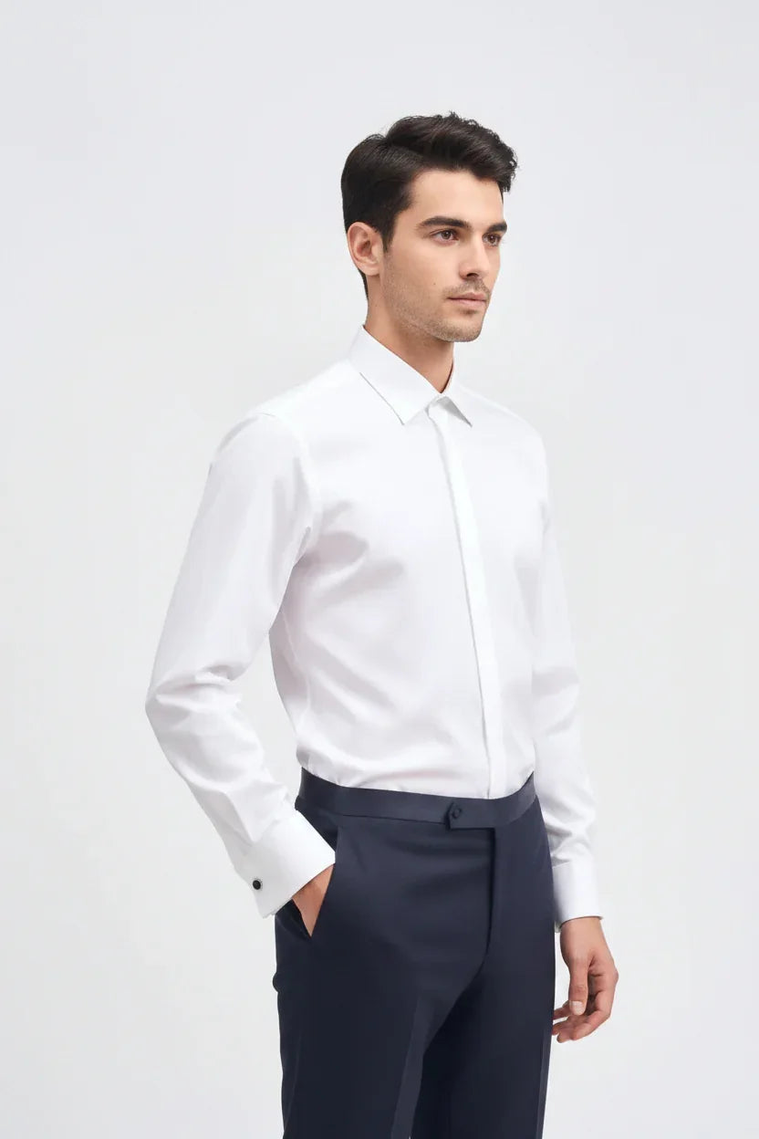 Modello uomo indossa camicia bianca elegante a maniche lunghe e pantaloni blu scuro