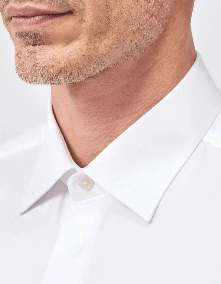 Camicia uomo bianca elegante con collo classico, dettaglio tessuto sartoriale.