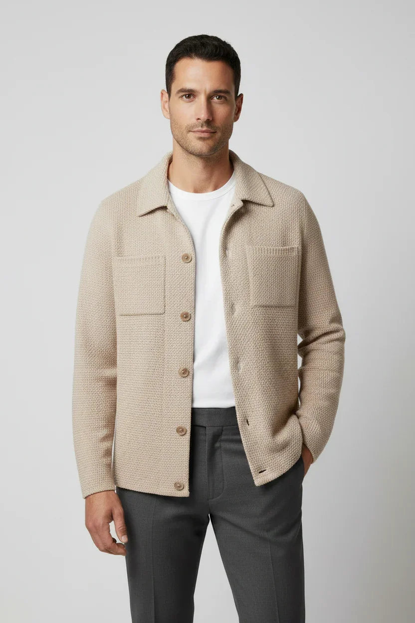 Uomo con cardigan beige in maglia, camicia bianca e pantaloni grigi, stile elegante