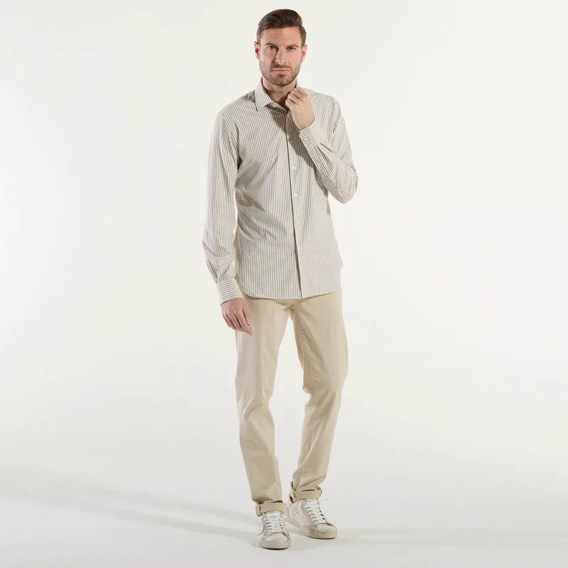 Modello uomo indossa camicia beige a righe e pantaloni chiari, look elegante casual.