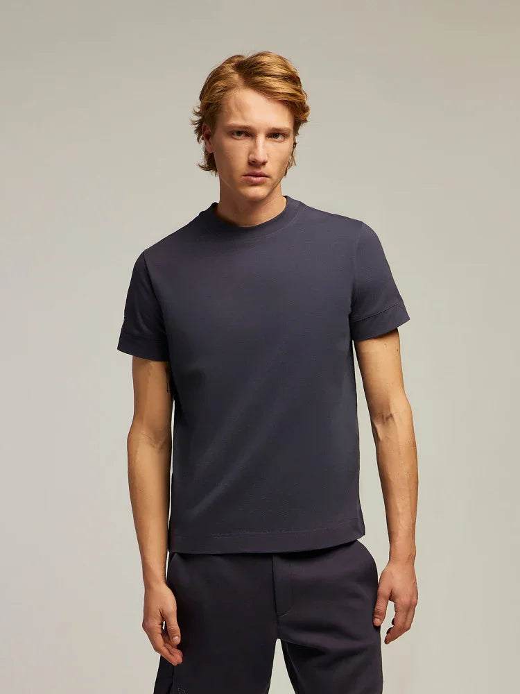 Modello indossa t-shirt uomo blu scuro in cotone, stile casual, su sfondo neutro.