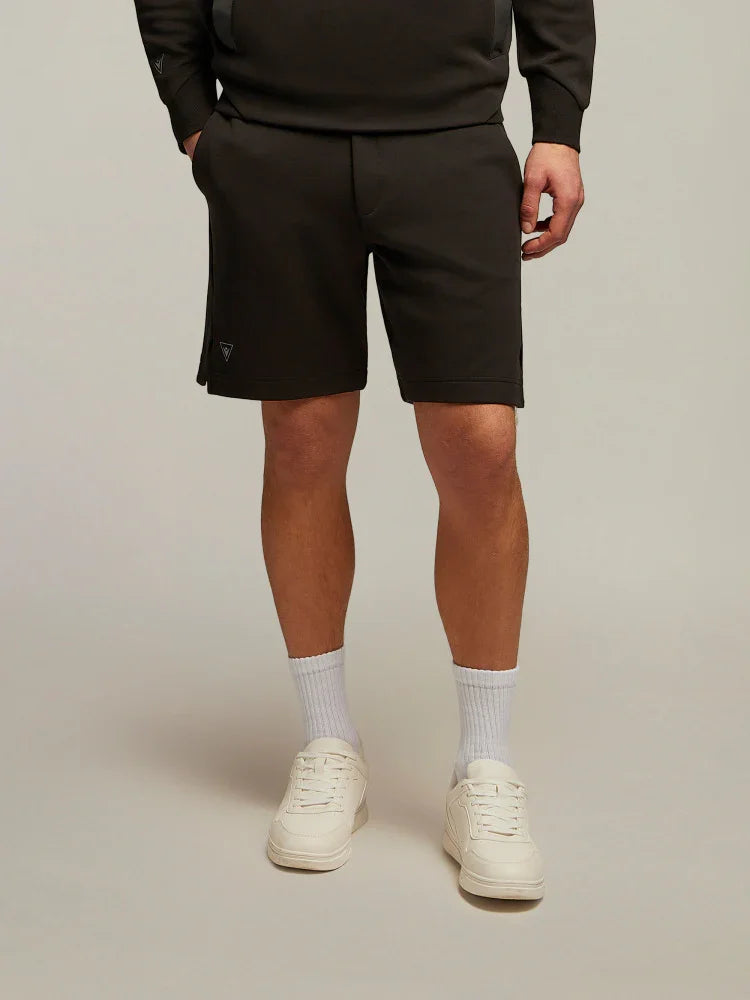 Bermuda uomo neri sportivi con sneakers bianche e calzini bianchi, stile casual moda uomo.
