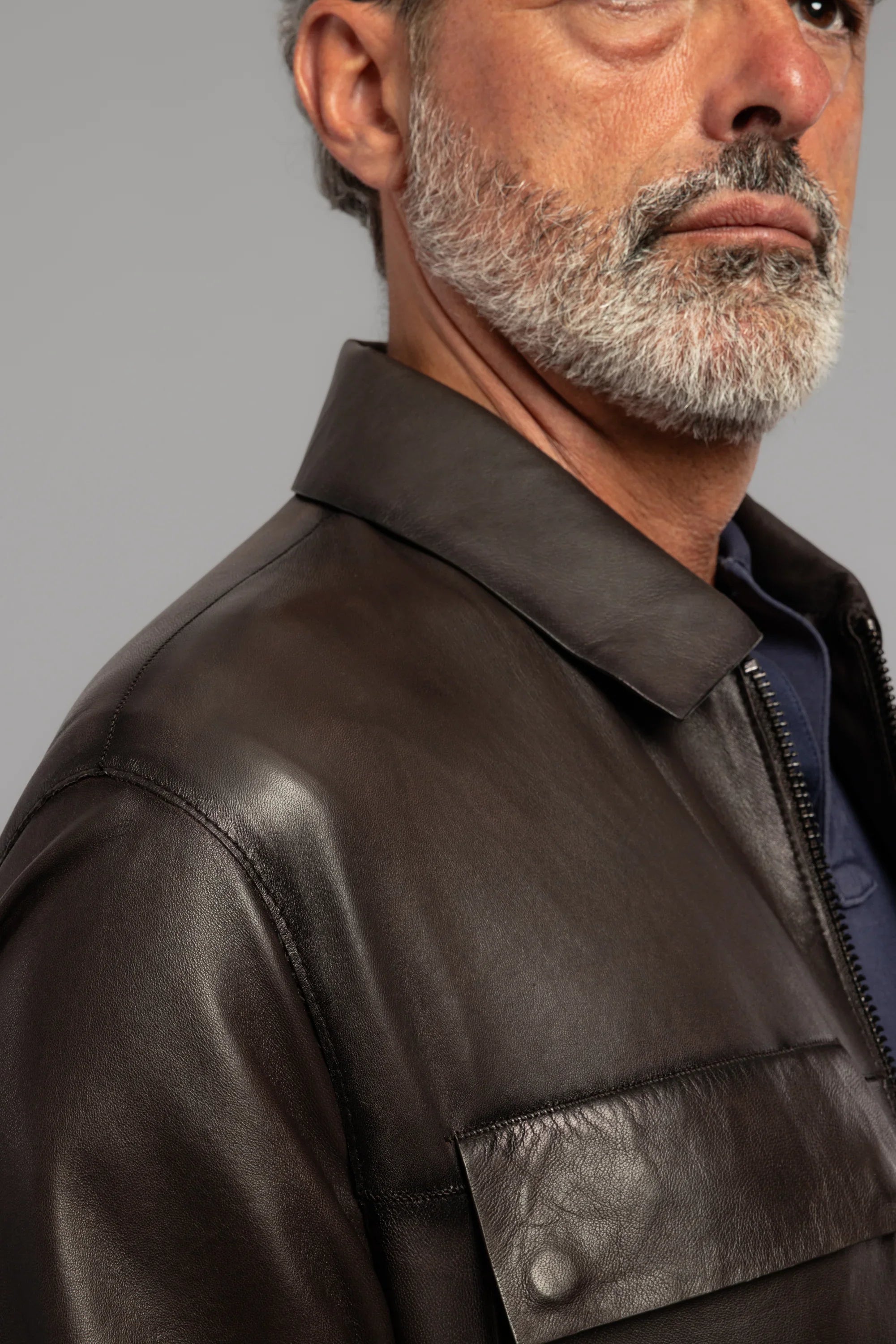 Giacca uomo in pelle marrone con tasca frontale, dettaglio texture e zip