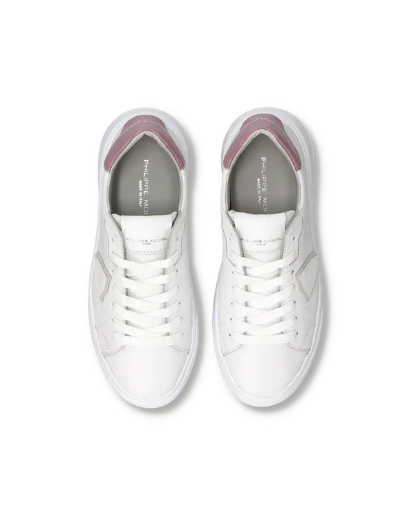 Sneakers bianche da uomo con dettagli rosa, vista dall’alto, stile casual elegante.