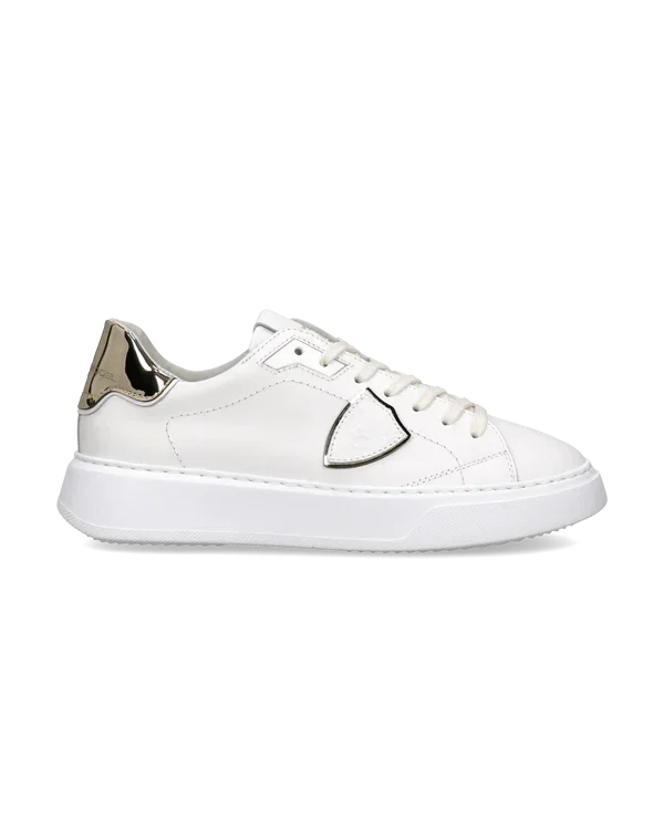 Sneaker donna bianca in pelle con dettagli metallici dorati, suola piatta, stile elegante