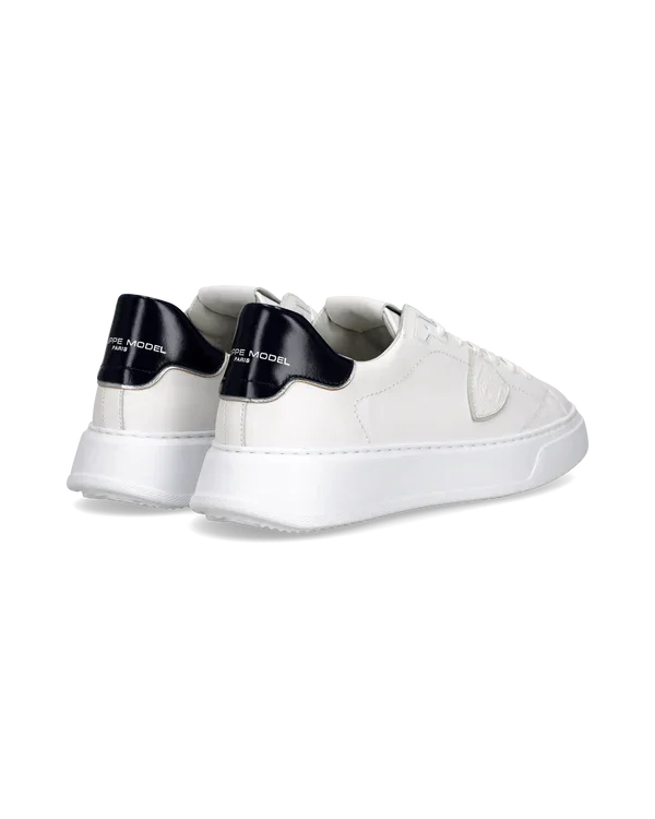 Sneakers bianche uomo in pelle con dettagli blu navy sul tallone, stile casual elegante.