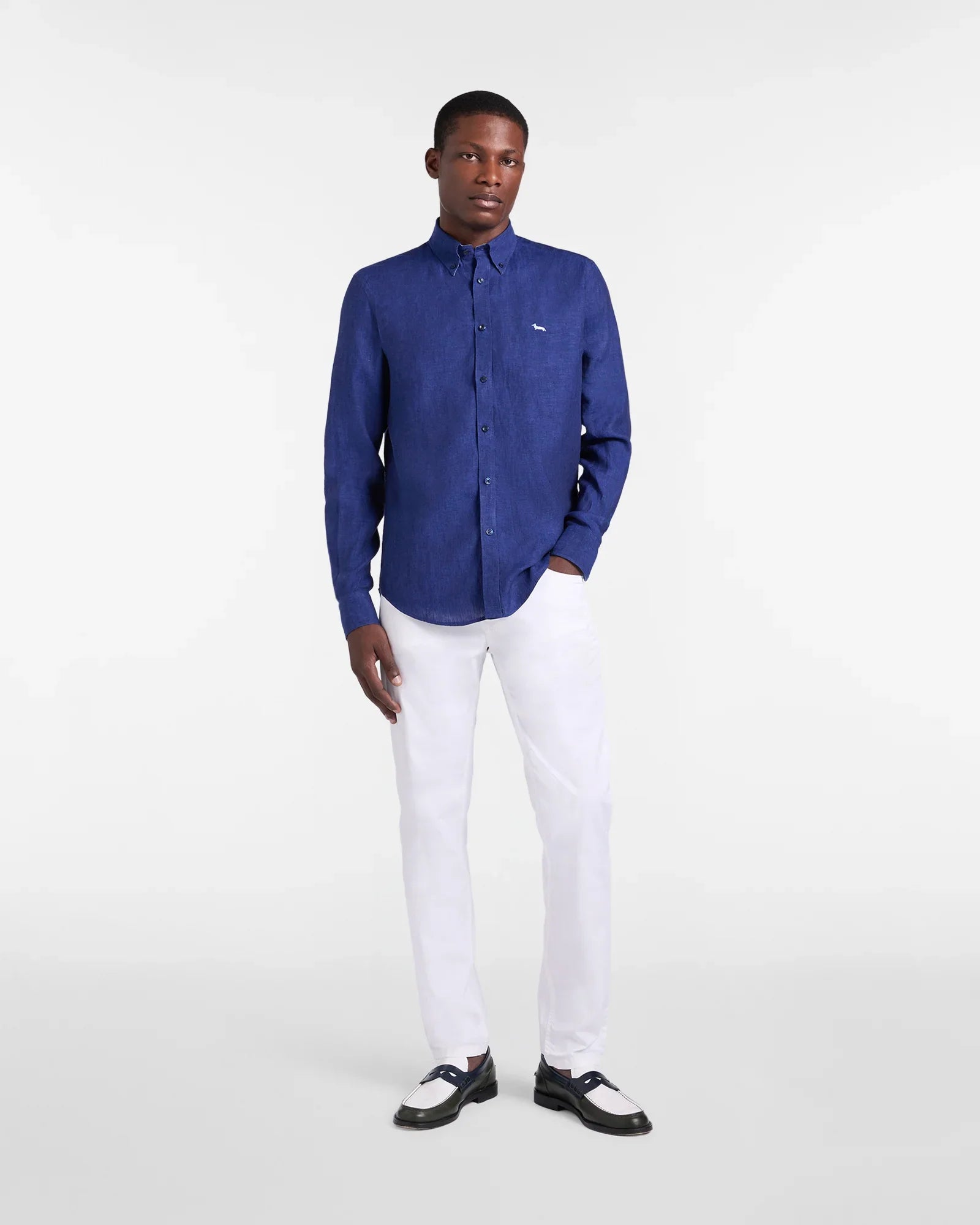 Modello indossa camicia blu uomo a maniche lunghe e pantaloni bianchi eleganti