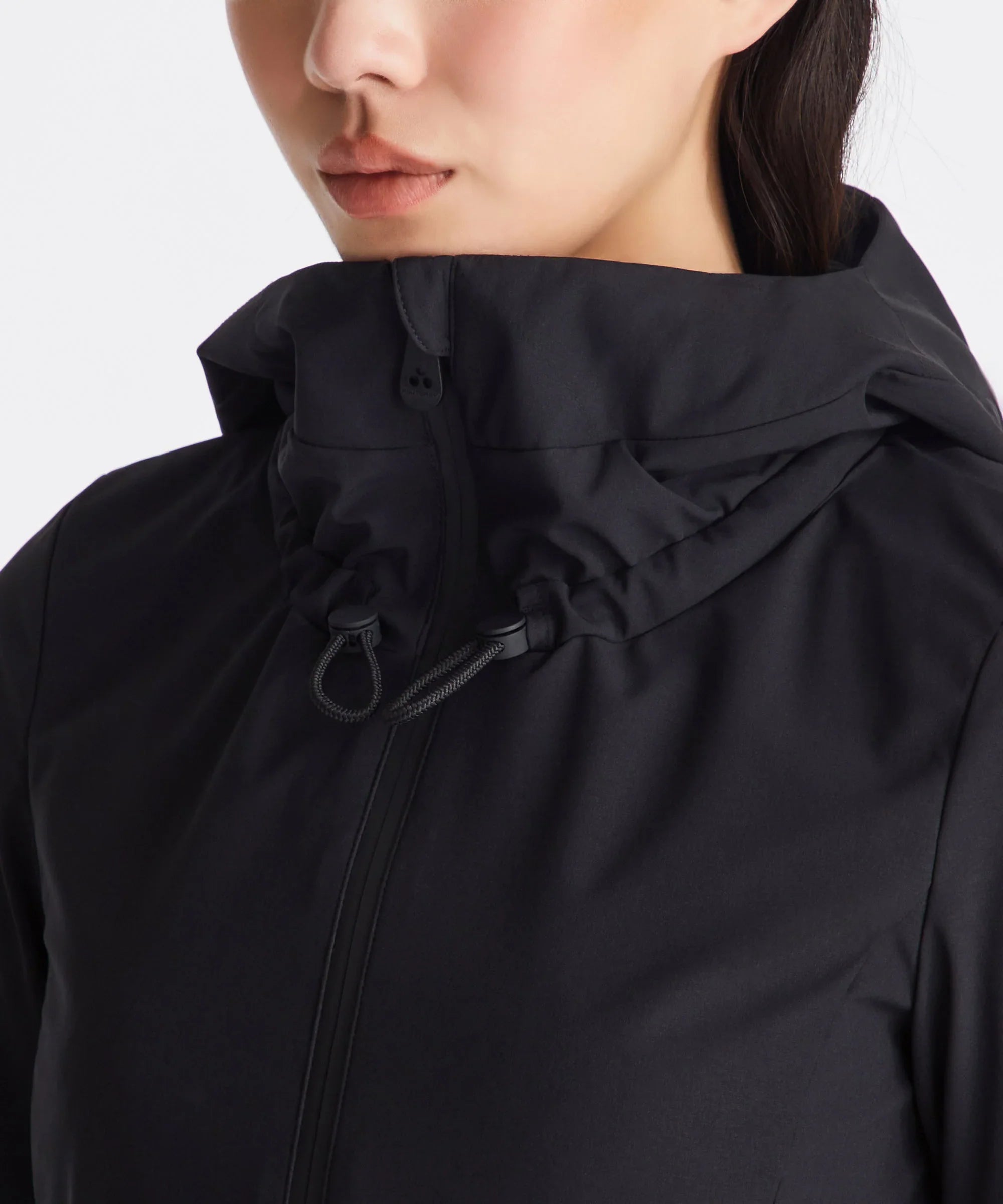 Giacca nera da donna con collo alto e chiusura zip, dettaglio laccio regolabile.