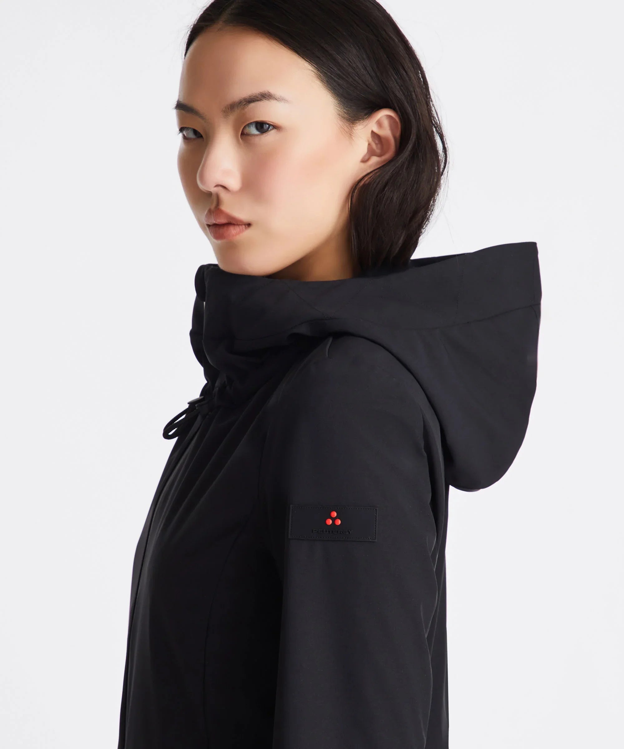 Giacca donna nera con cappuccio e patch Peuterey sulla manica, moda elegante.