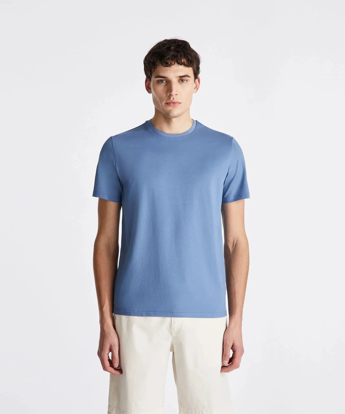 Modello uomo con t-shirt azzurra e bermuda beige, abbigliamento casual estivo