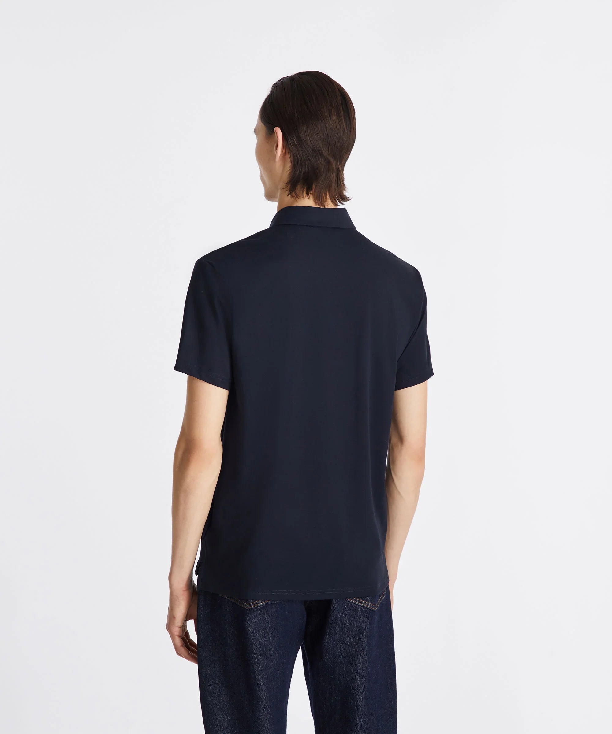 Uomo di spalle con polo blu scuro e jeans, moda abbigliamento maschile casual