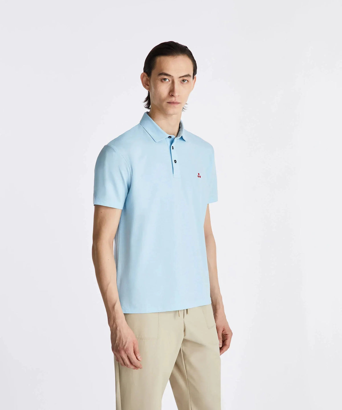 Uomo con polo celeste a maniche corte e pantaloni beige, moda abbigliamento uomo elegante.