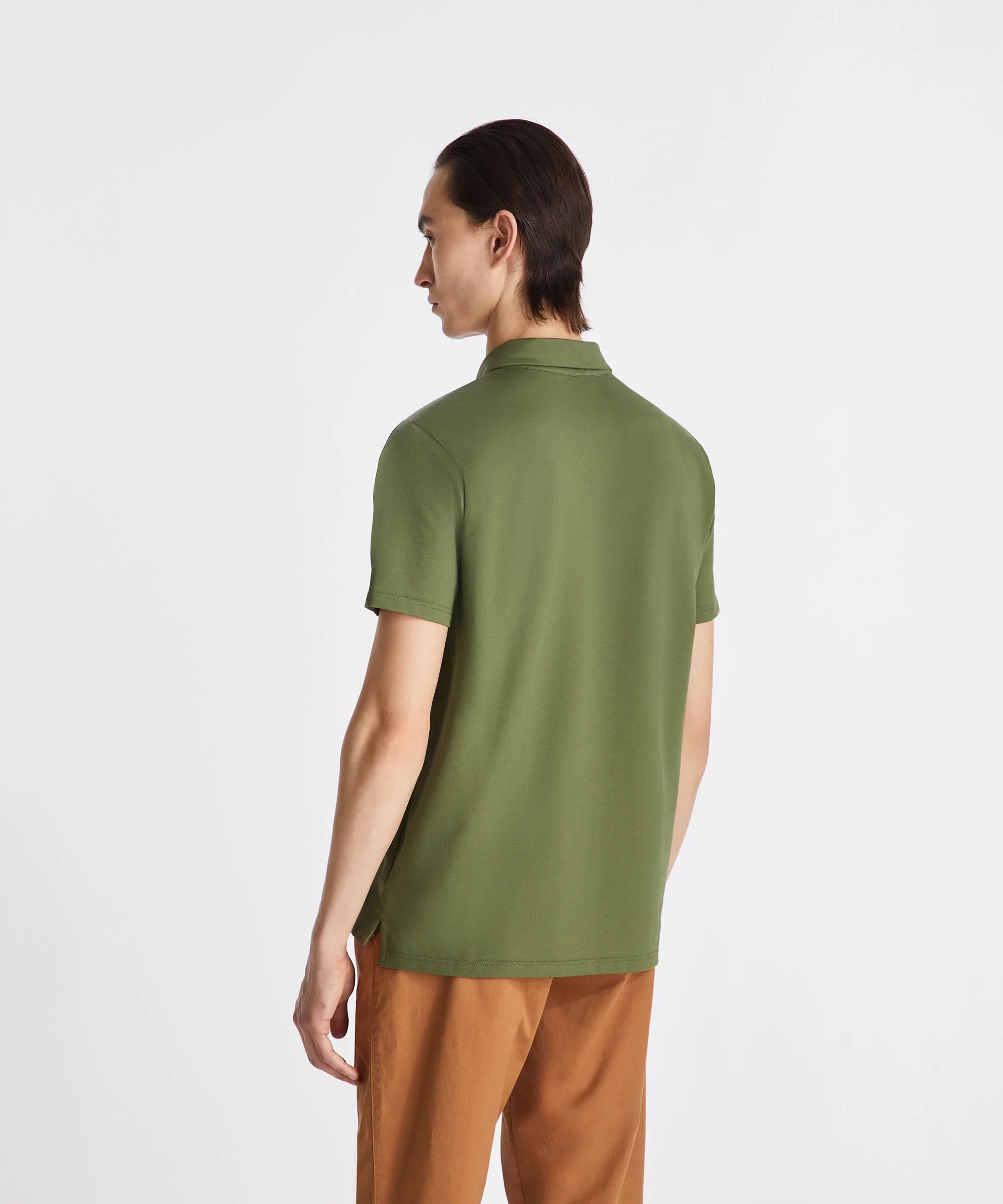 Uomo di spalle con polo verde e pantaloni marroni, moda abbigliamento casual uomo