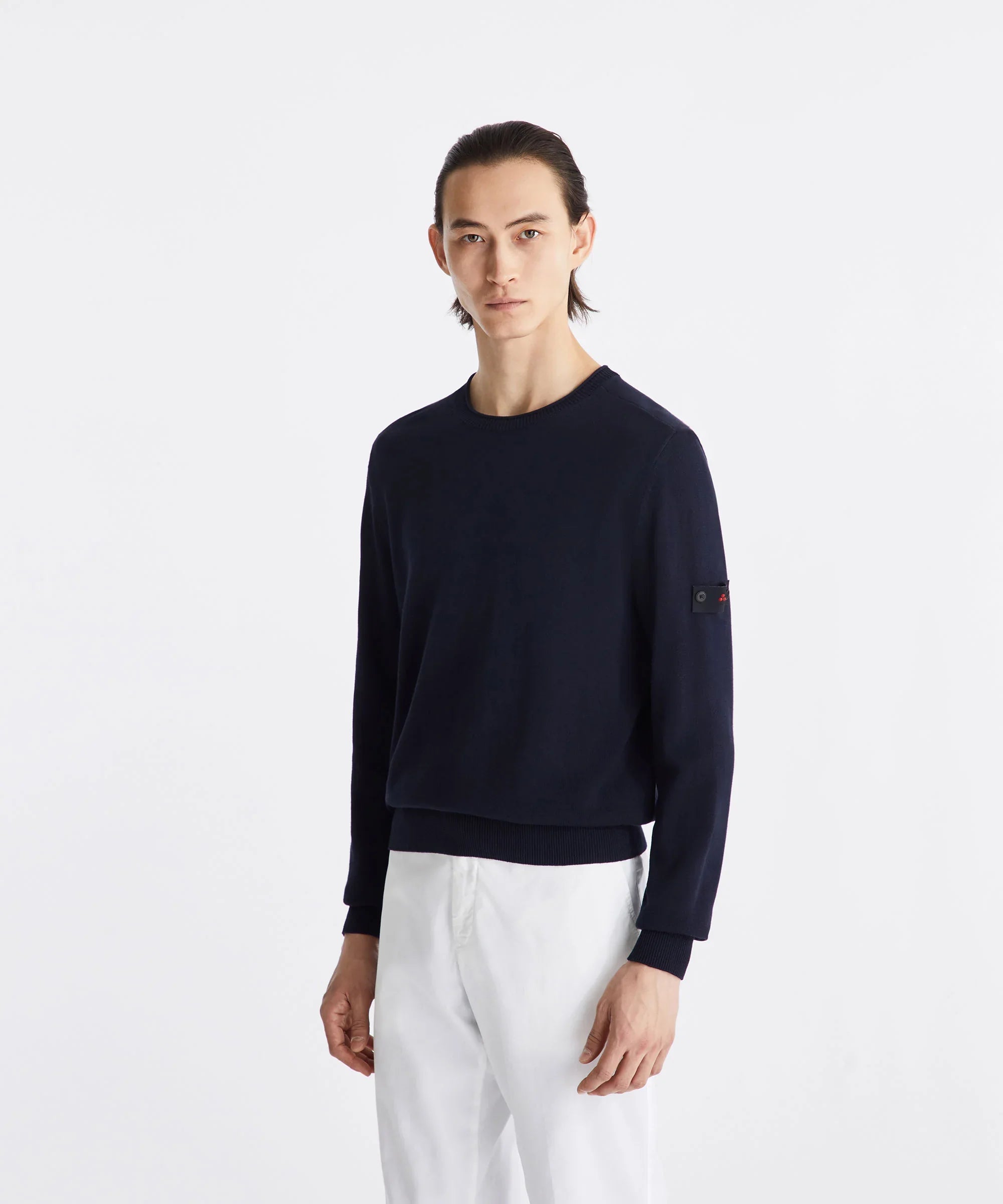 Maglione uomo blu scuro a maniche lunghe, vestibilità regular, indossato su pantaloni bianchi, stile elegante casual.