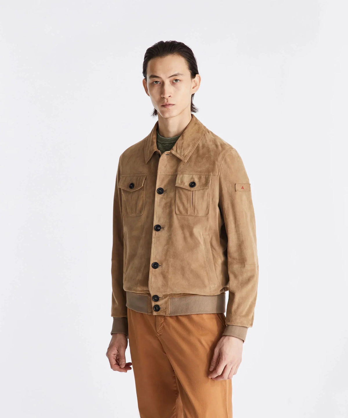 Giacca scamosciata uomo color cammello con tasche frontali e pantaloni beige, moda elegante.
