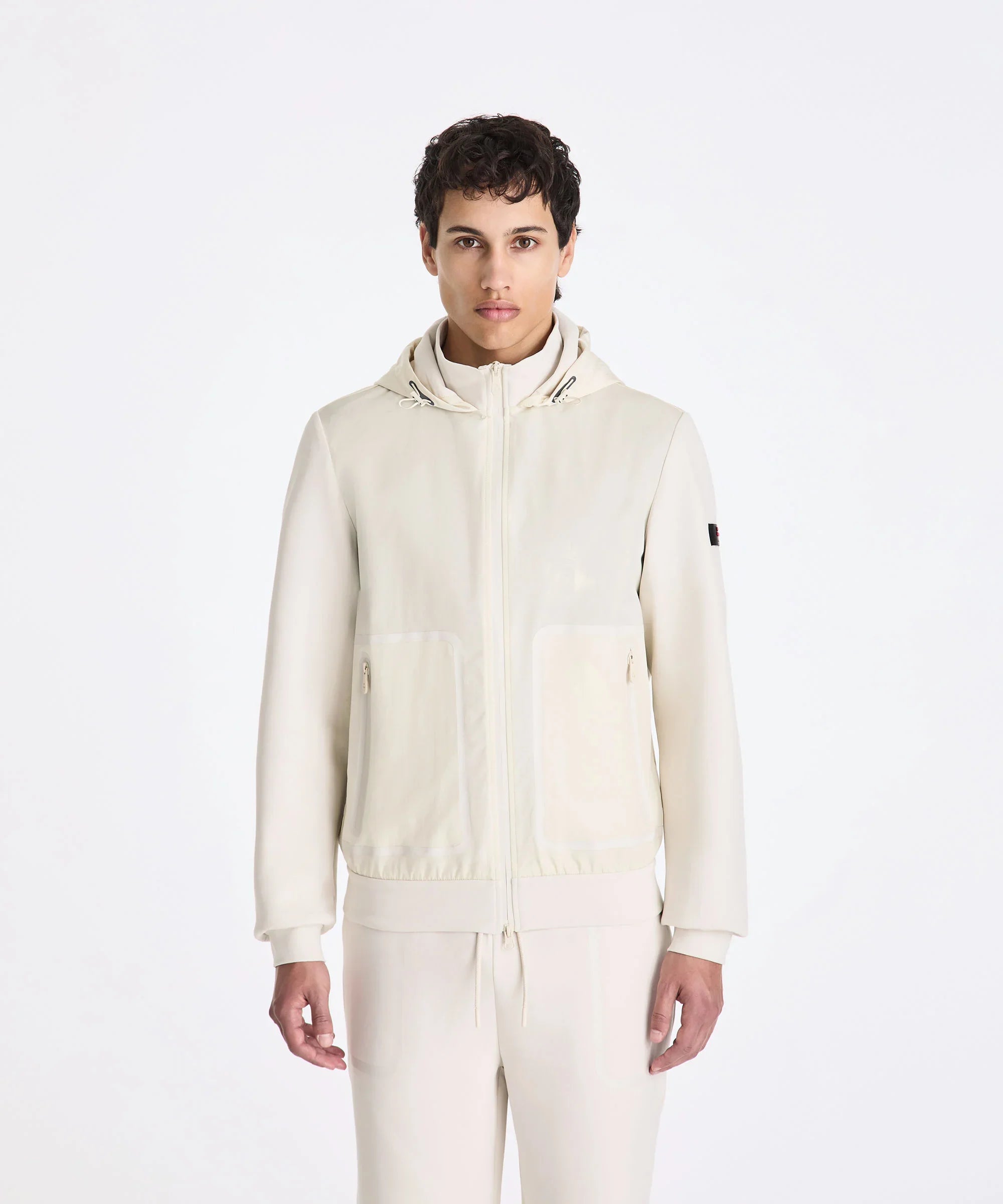 Giacca uomo beige chiaro con cappuccio e zip, look casual elegante, moda primavera