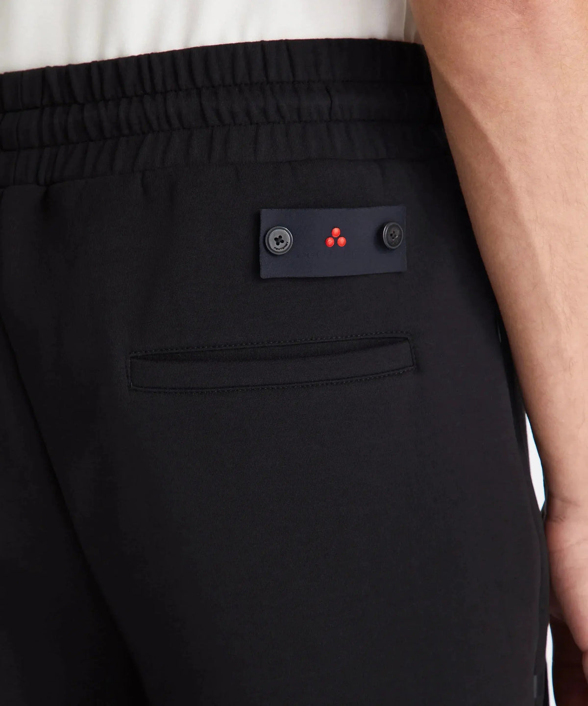dettaglio pantaloni neri uomo con elastico in vita e tasca posteriore, moda casual