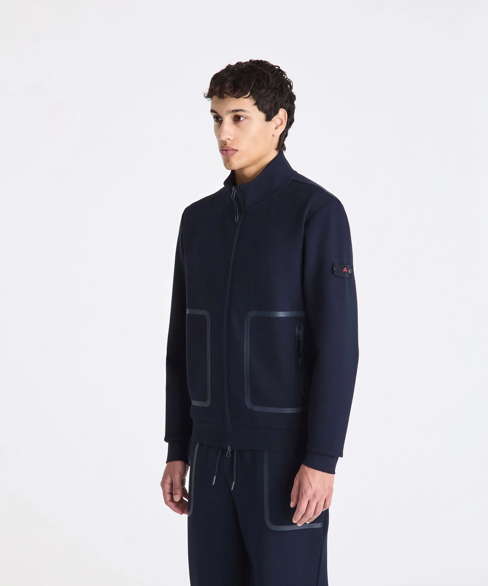 Giacca uomo blu scuro con zip, tasche quadrate e dettagli moderni, abbigliamento elegante.