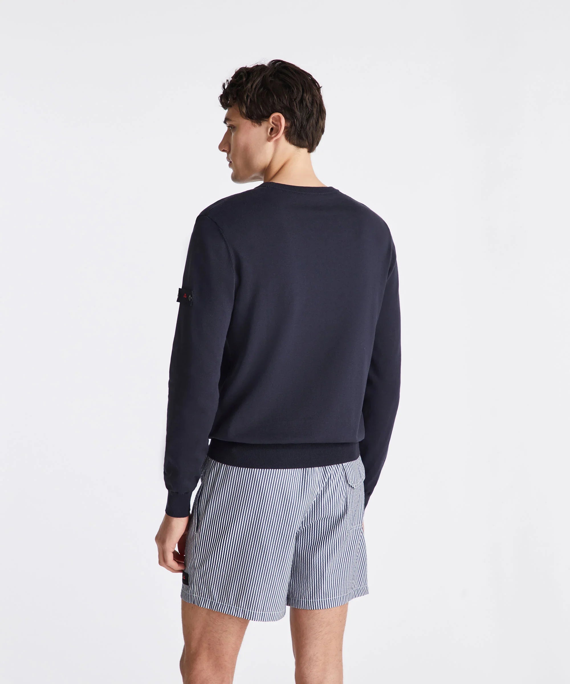 Modello uomo di spalle con felpa blu e boxer rigati bianchi e blu, stile casual